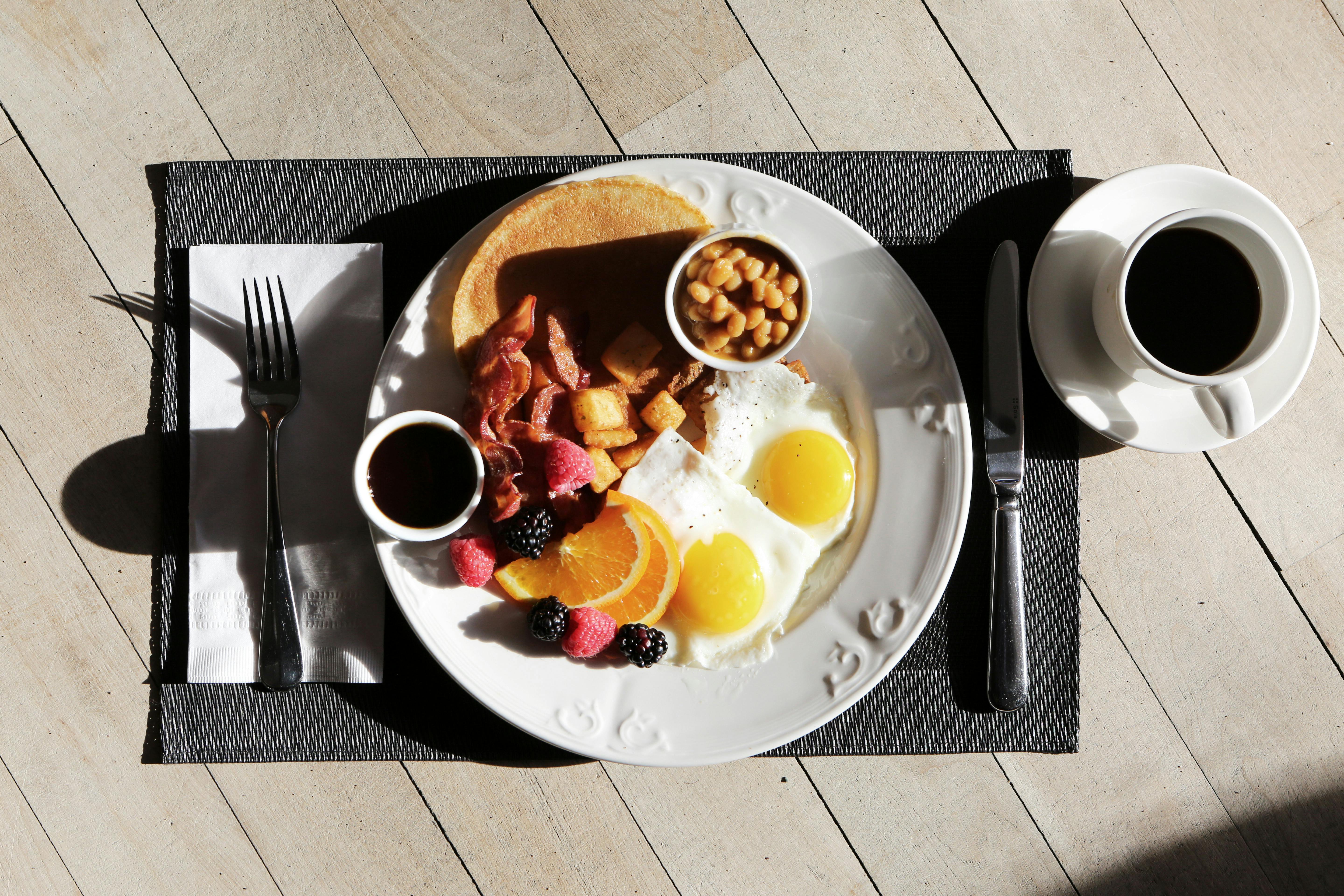Brunch plate with eggs, pancakes, and fresh fruit